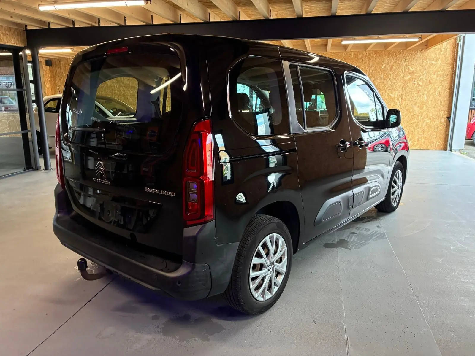Vue 3/4 arrière droite d'un Citroën Berlingo noir 2020 avec hayon, porte latérale coulissante et attelage visible.
