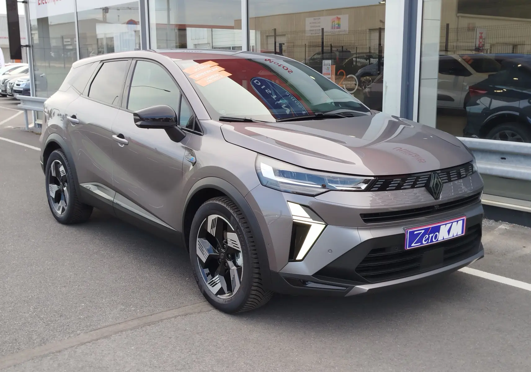 Renault Symbioz gris cassiopée métal en 3/4 avant droit, avec feux LED et jantes noires distinctives.