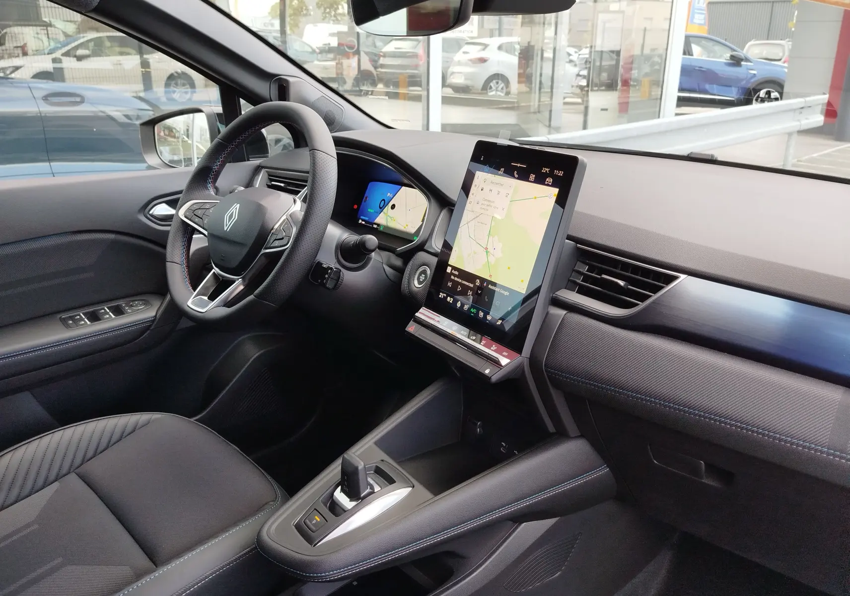 Vue intérieure côté gauche du Renault Symbioz gris cassiopée, avec tableau de bord numérique et écran tactile vertical central.