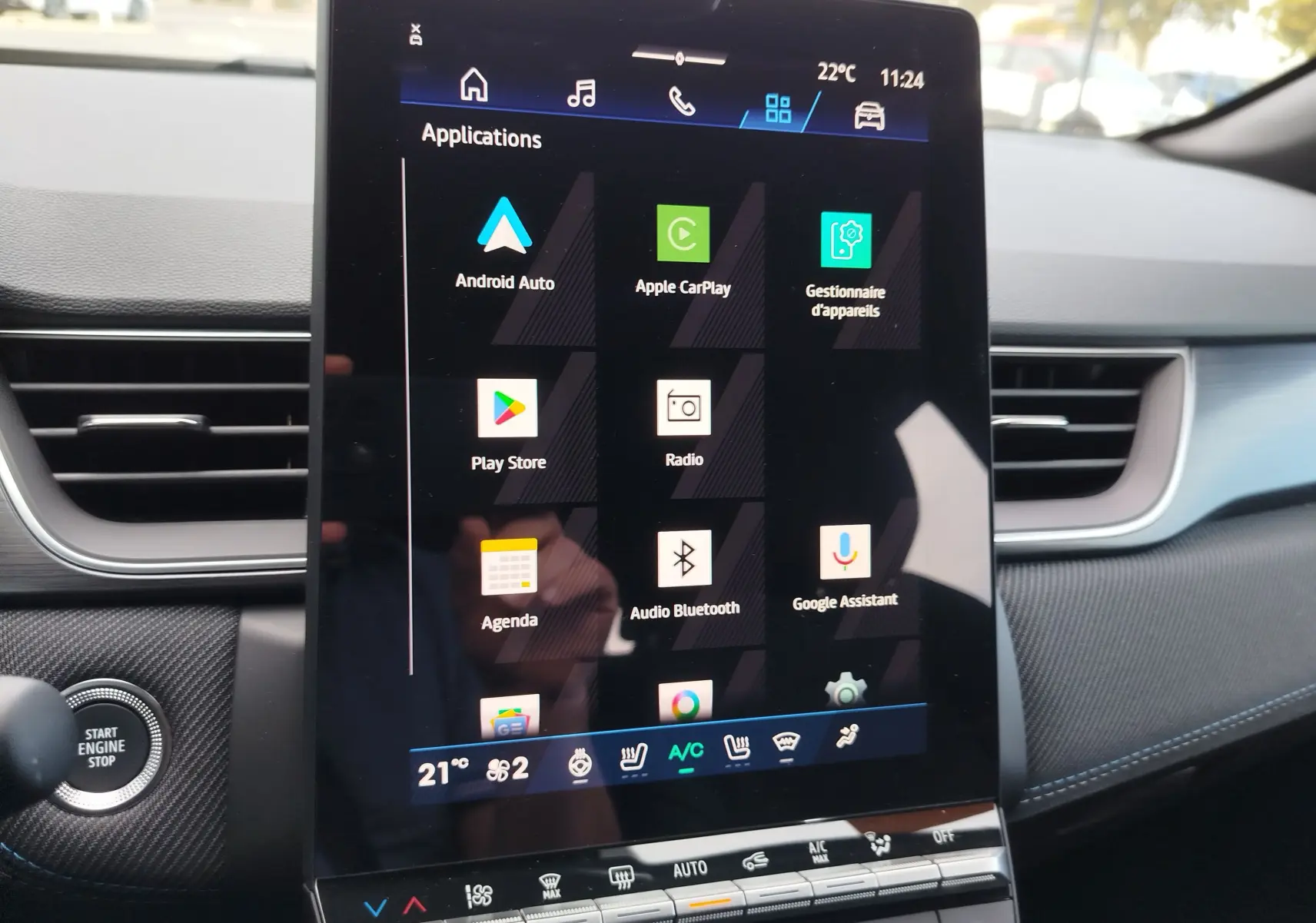 Vue intérieure centrée sur l'écran tactile vertical du tableau de bord du Renault Symbioz gris cassiopée, affichant les applications connectées.
