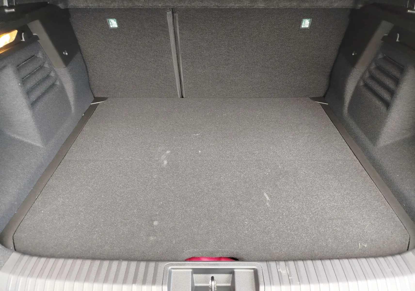 Vue intérieure du coffre spacieux et propre du Renault Symbioz gris Cassiopée Métal, avec revêtement textile noir.