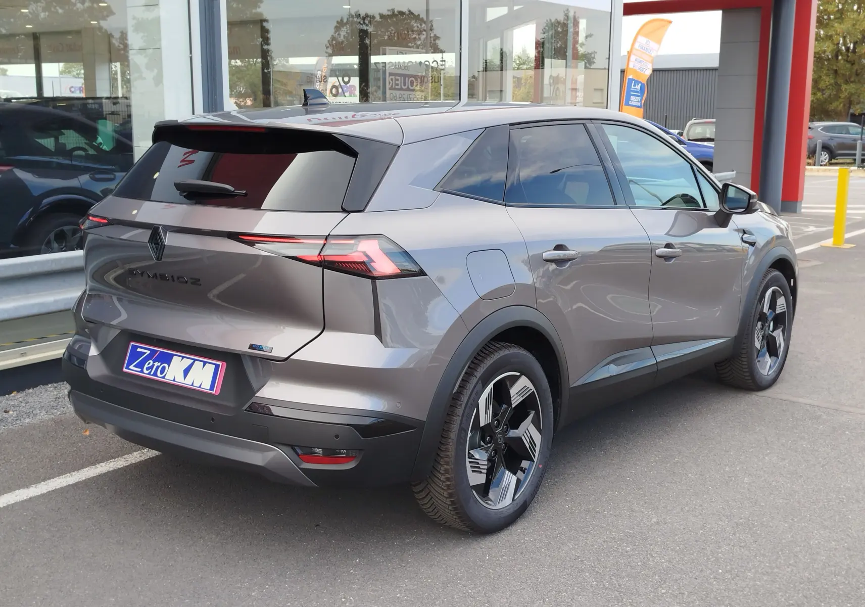 Vue 3/4 arrière droite du Renault SYMBIOZ gris cassiopée métal avec feux arrière LED fins et jantes bicolores modernes.