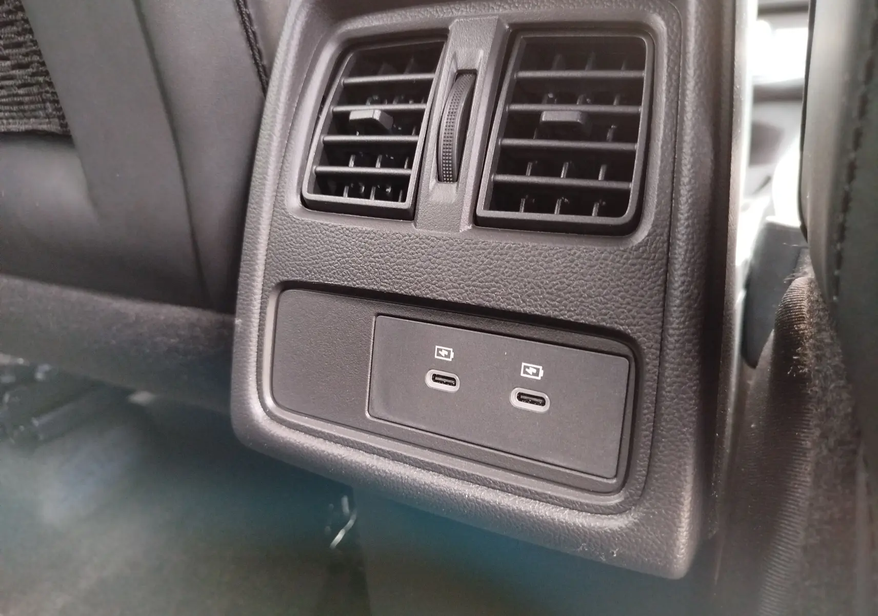 Vue rapprochée des prises USB-C doubles et des bouches d’aération arrière en plastique noir du Renault Symbioz 2026.