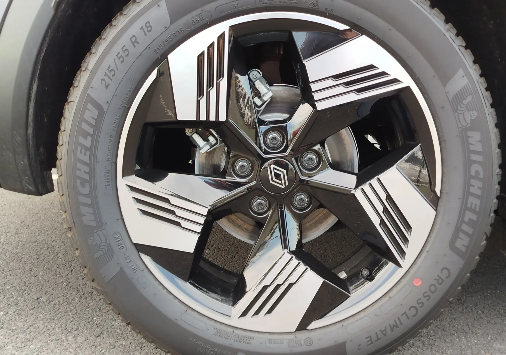 Gros plan sur la jante noire et argentée de 18 pouces avec logo Renault, montée sur pneu Michelin CrossClimate 2.
