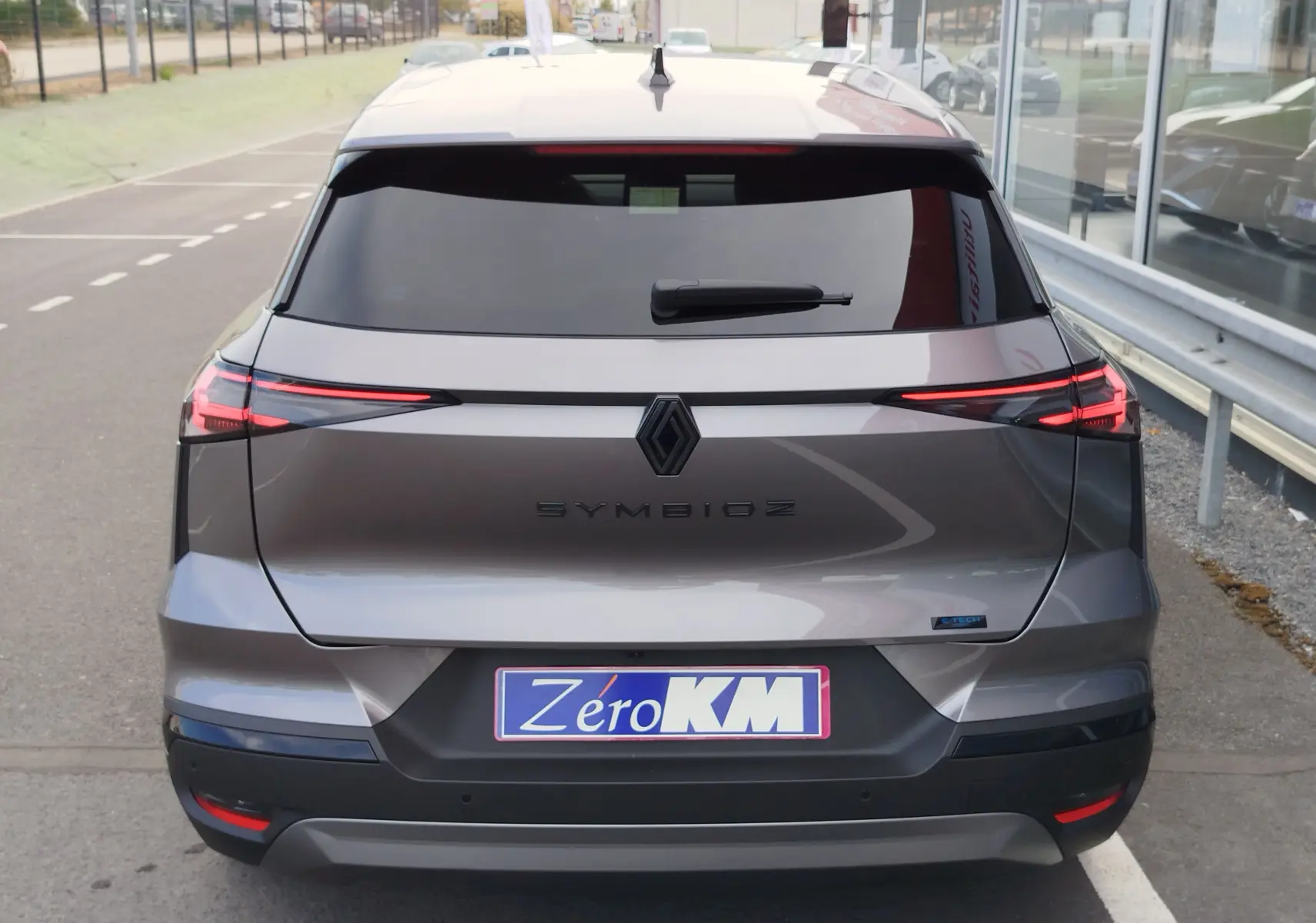 Vue arrière d'une Renault Symbioz gris cassiopée métal avec feux LED fins et logo central noir mat.