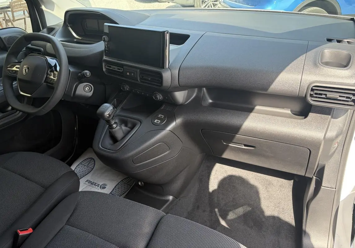 Vue intérieure côté conducteur du Peugeot Partner 2026 blanc, avec tableau de bord moderne et écran tactile central.