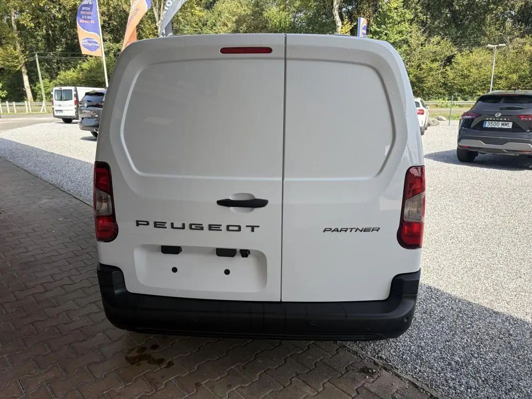 Vue arrière d’un fourgon blanc Peugeot Partner 2026 avec portes battantes et feux arrière rouges.