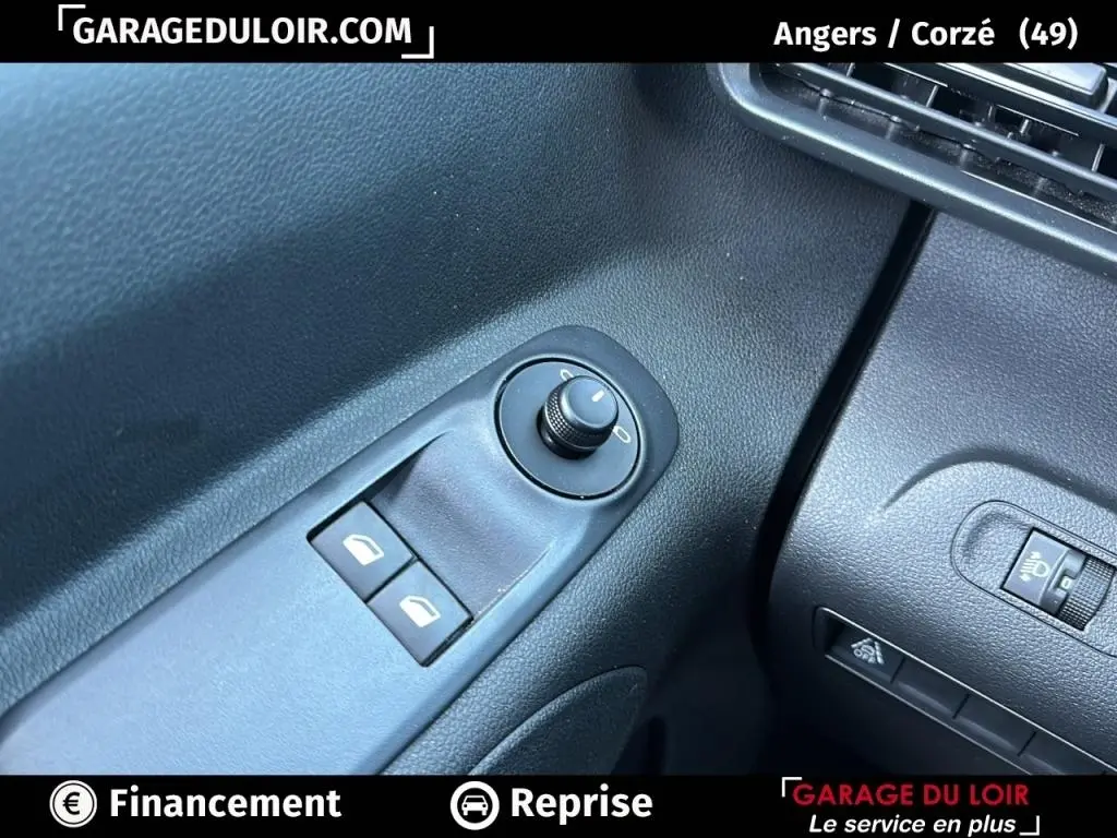 Détail des commandes de réglage des rétroviseurs et des vitres côté conducteur, intérieur noir du Peugeot Rifter bleu 2024.