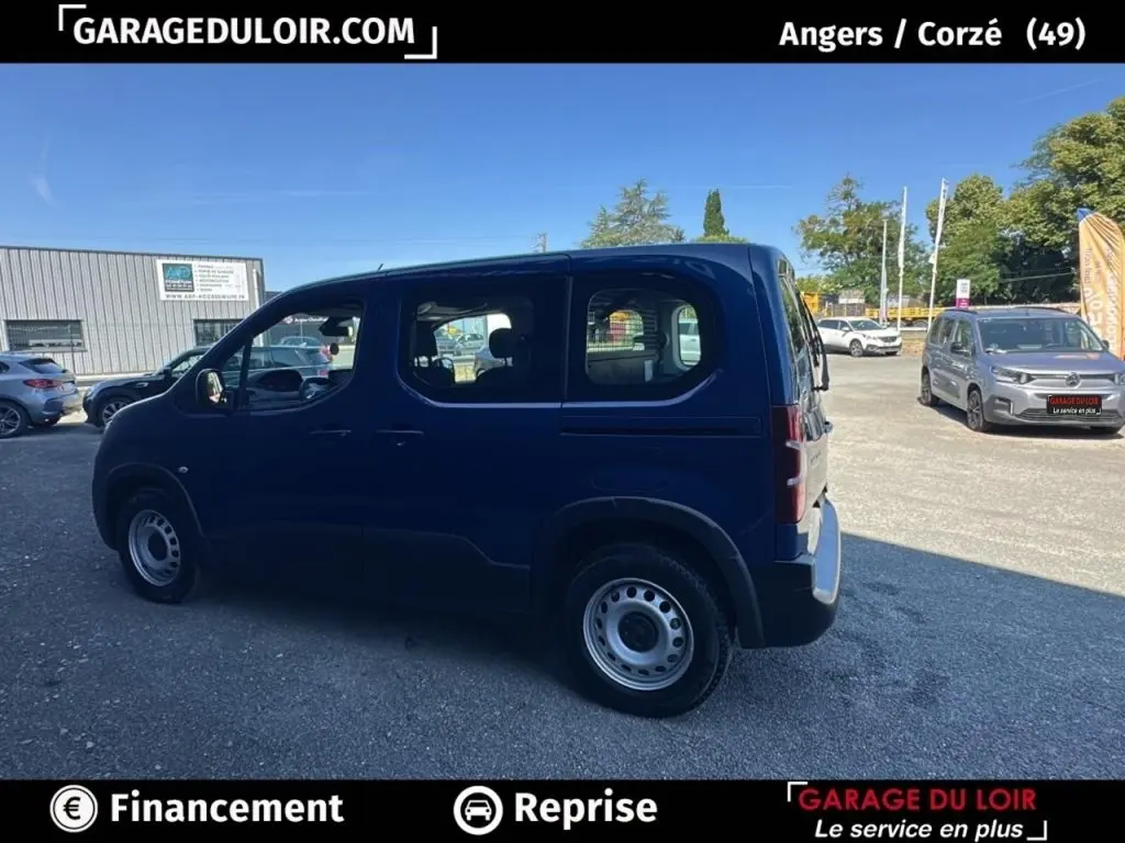 Vue latérale droite d’un Peugeot Rifter 1.5 BlueHDi bleu 2024 avec jantes acier, stationné en extérieur.