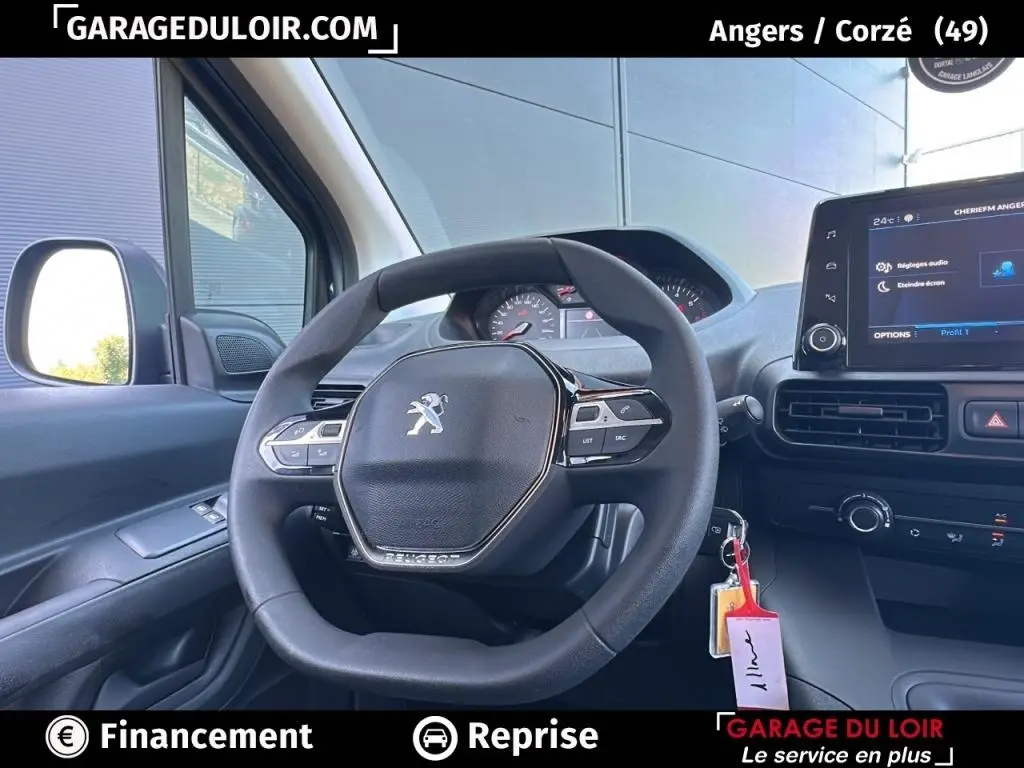 Vue intérieure centrée sur le volant Peugeot du Rifter 2024, avec tableau de bord et écran tactile visibles.