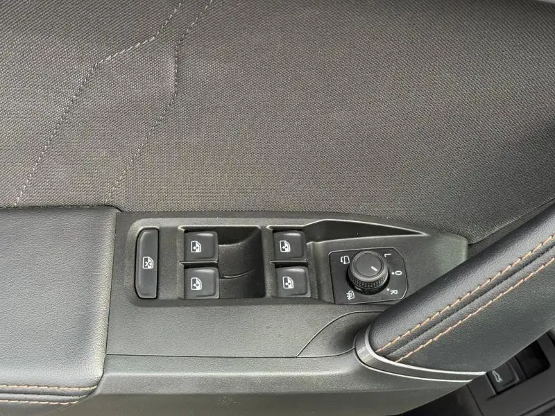 Gros plan sur les commandes de lève-vitres et rétroviseurs sur la porte côté conducteur d'un CUPRA Formentor 2025.