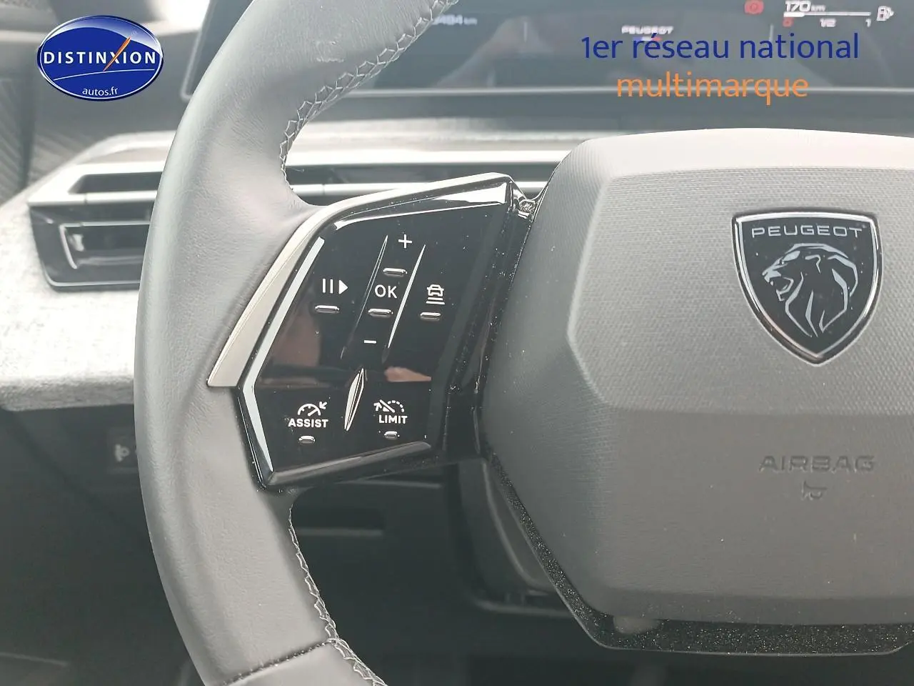 Gros plan sur le volant cuir gris du Peugeot 3008 2025 avec commandes multifonctions et logo lion central.