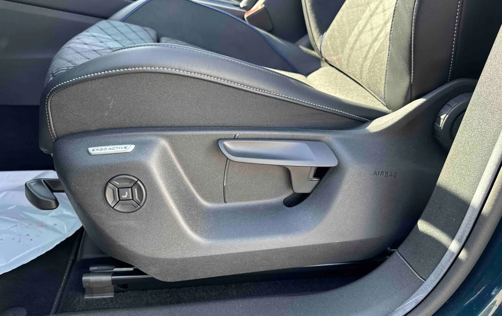Gros plan sur le siège conducteur ErgoActive du Volkswagen Tiguan 2025, montrant les commandes de réglage côté gauche.