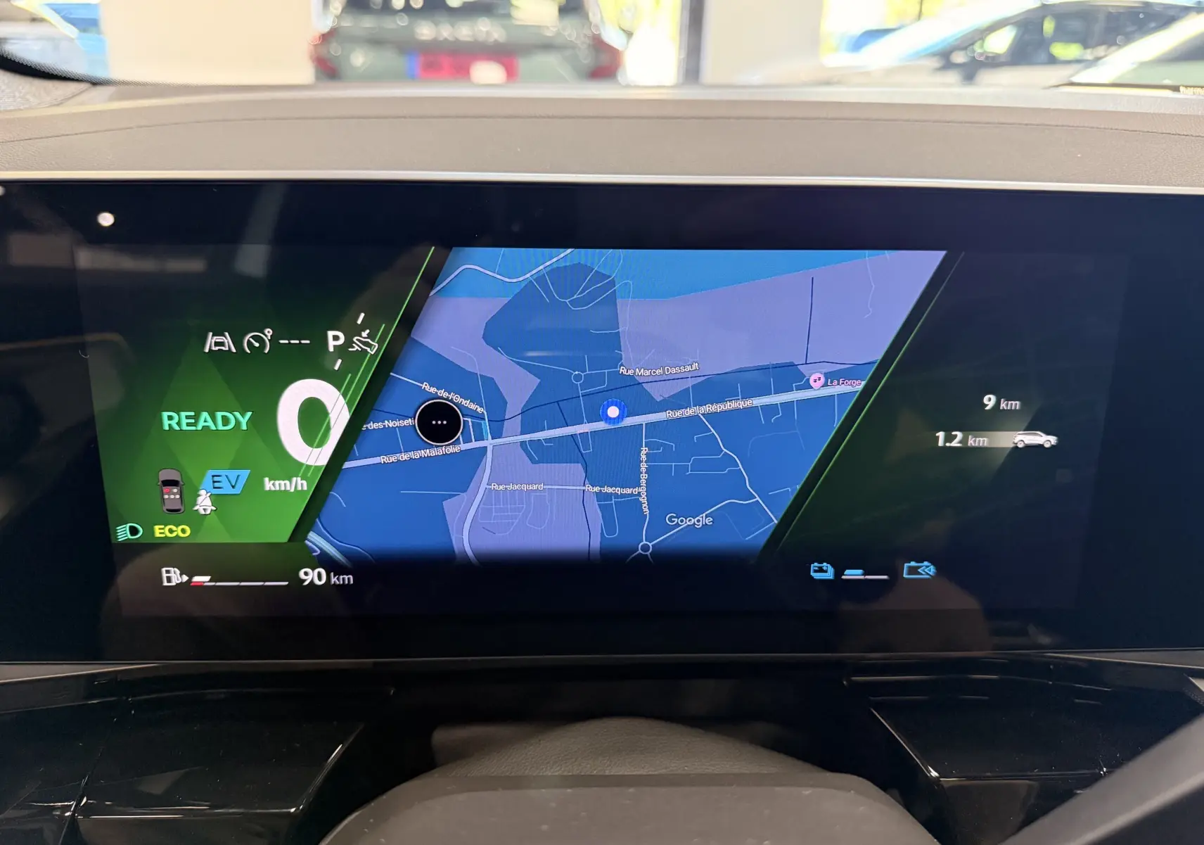 Affichage numérique intérieur du tableau de bord Renault Austral 2026, avec navigation GPS et indicateurs de conduite hybride.