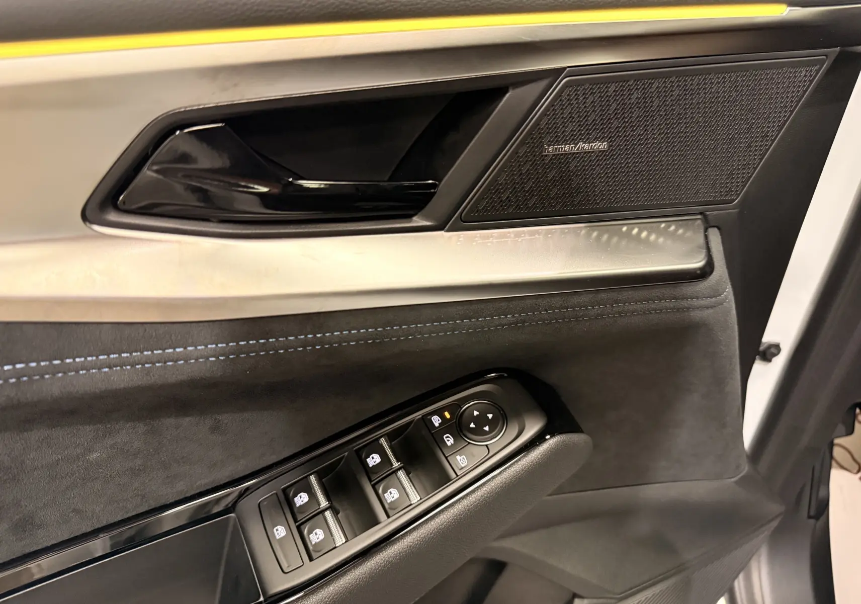 Détail de la porte avant gauche du Renault Austral blanc nacré, avec commandes de vitres et haut-parleur Harman Kardon.