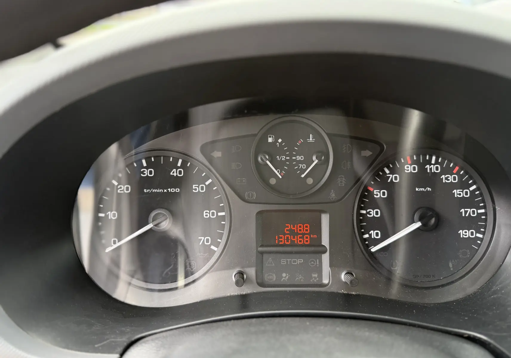 Vue rapprochée du tableau de bord du Peugeot Partner blanc 2017, affichant compte-tours, vitesse et jauges.