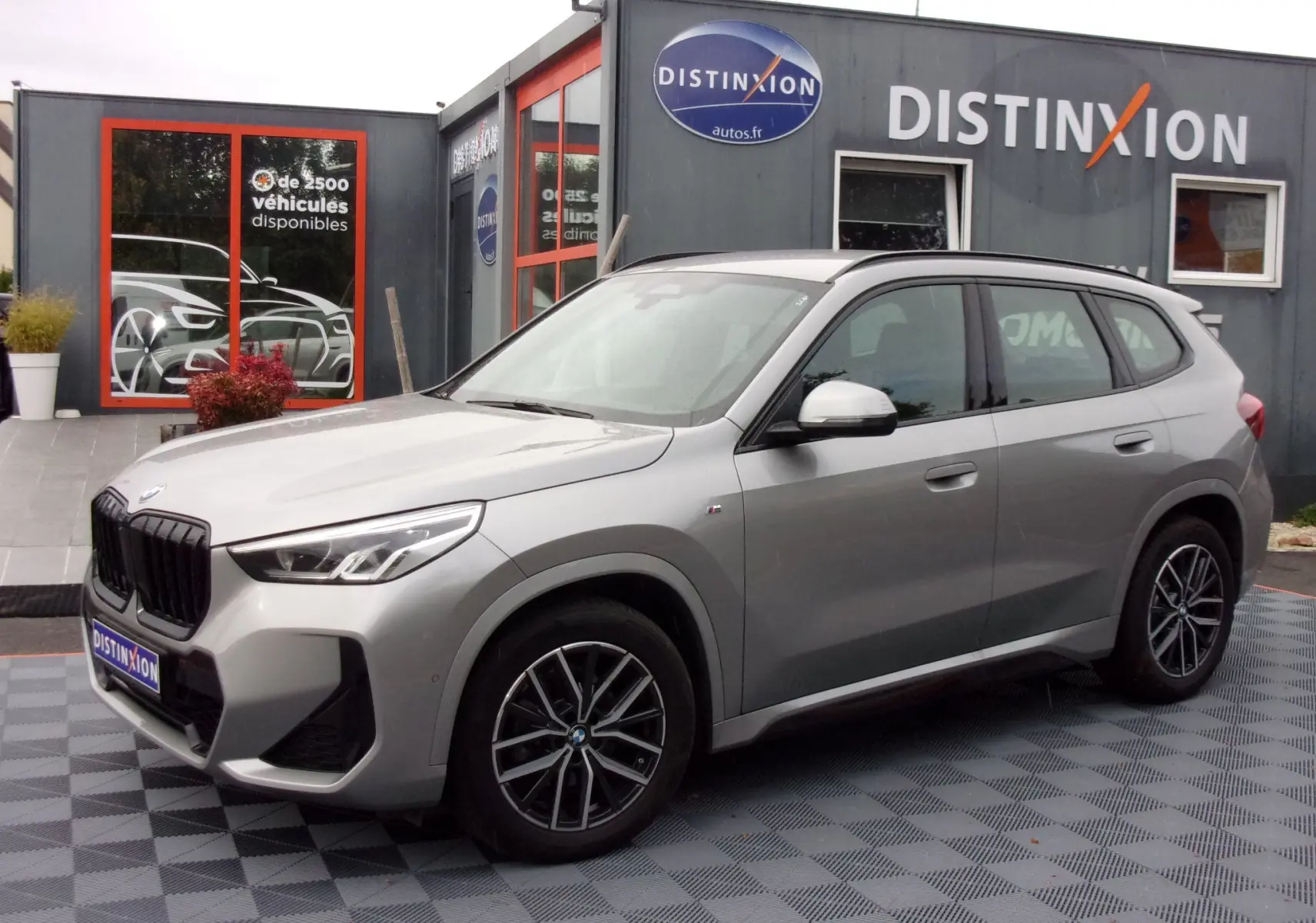 BMW X1 U11 xDrive 20d 2024 argent métallisé en 3/4 avant droit, avec jantes alliage et calandre noire M Sport.