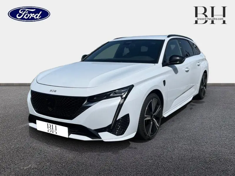Peugeot 308 SW PHEV blanc Okénite vue 3/4 avant droit avec jantes alu noires et calandre noire distinctive