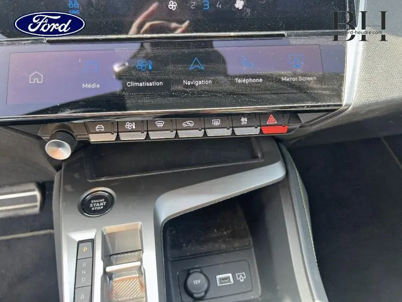 Console centrale avec écran tactile et commandes, bouton start/stop, prise 12V et USB dans une Peugeot 308 SW blanc Okénite.
