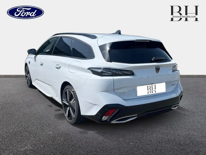 Peugeot 308 SW PHEV blanc Okénite vue 3/4 arrière droit avec vitres surteintées et jantes alu noires.