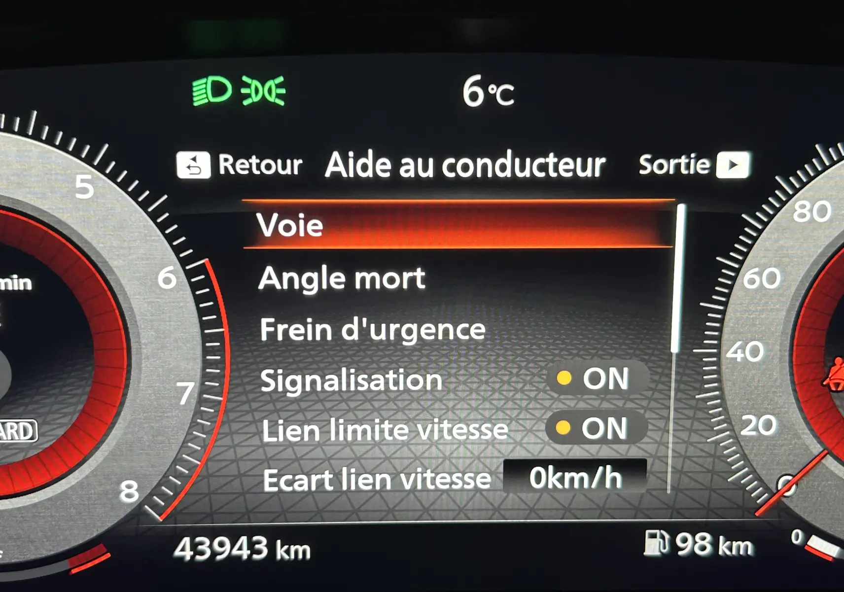 Affichage numérique du tableau de bord du Nissan Qashqai blanc lunaire 2023, montrant les aides à la conduite activées.