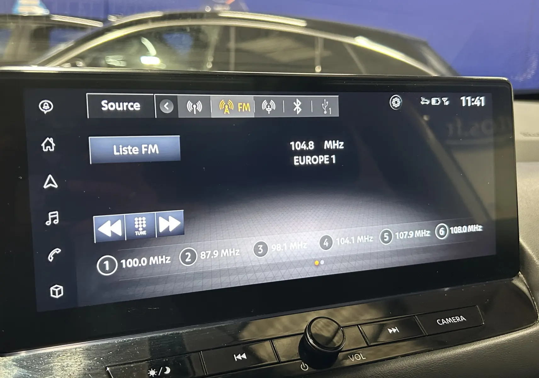 Écran tactile multimédia du Nissan Qashqai blanc lunaire, affichant la radio FM avec station Europe 1 à 104,8 MHz.