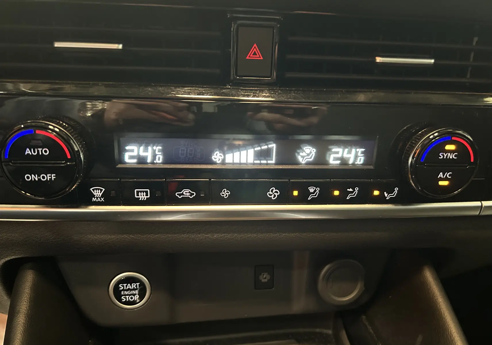 Gros plan sur la console centrale du Nissan Qashqai blanc lunaire, affichant la climatisation à 24°C avec commandes digitales.