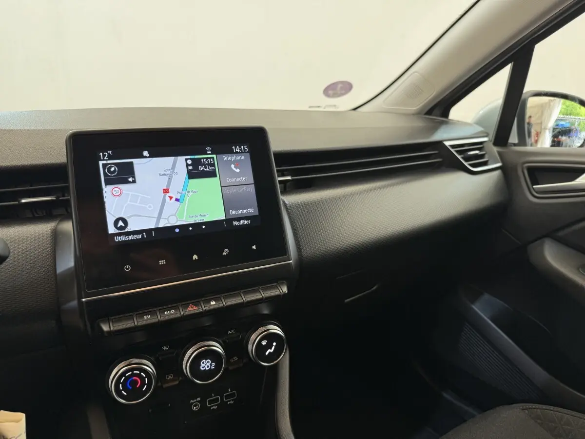 Vue intérieure côté passager de la Renault Clio Business E-Tech hybride 2021 avec écran tactile et tableau de bord noir.