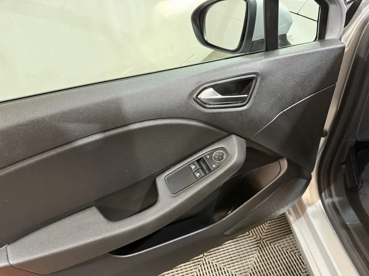 Vue rapprochée de la porte avant gauche gris clair de la Renault Clio Business E-Tech hybride 2021 avec commandes de vitres et rétroviseur.