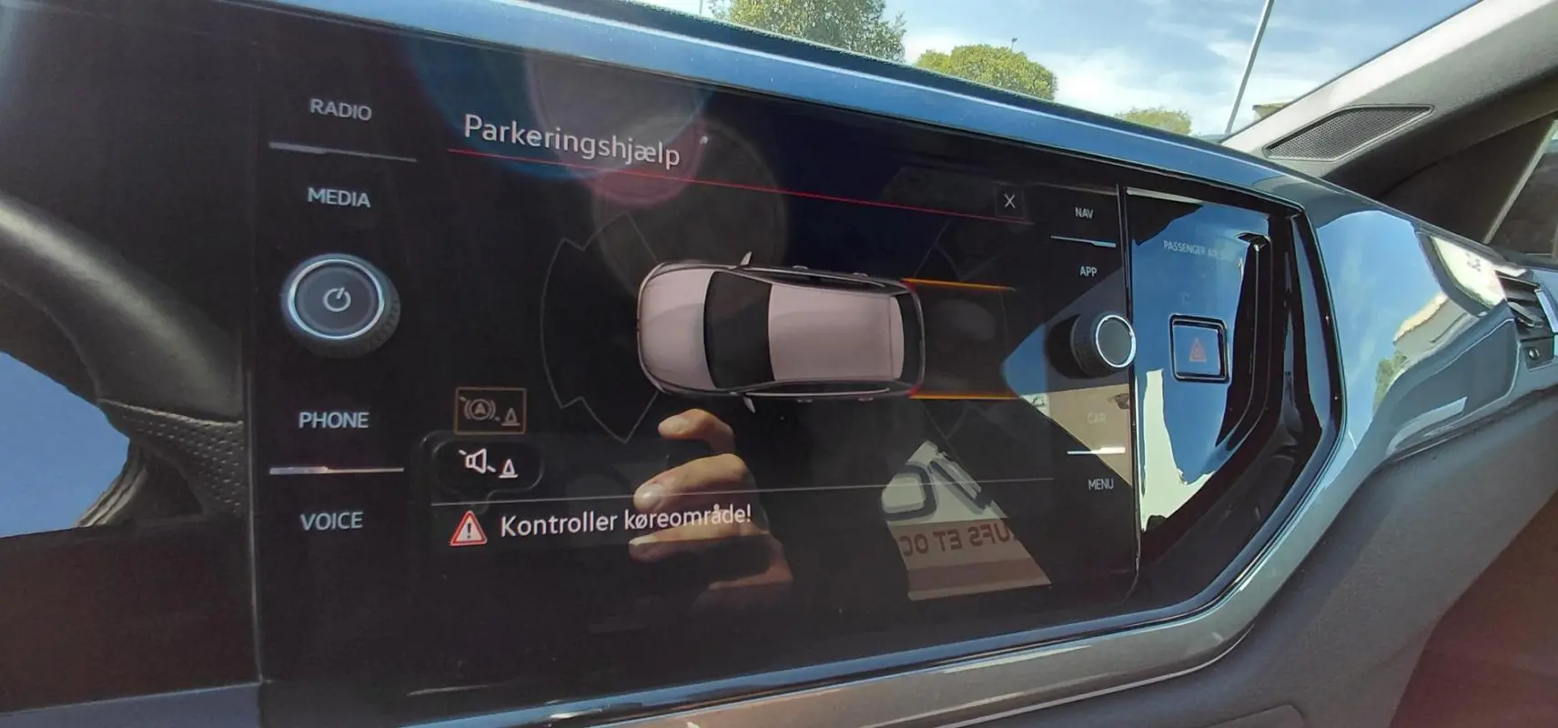 Écran tactile central de la Volkswagen Polo GTI 2024 noir montrant l'aide au stationnement et les commandes multimédia.