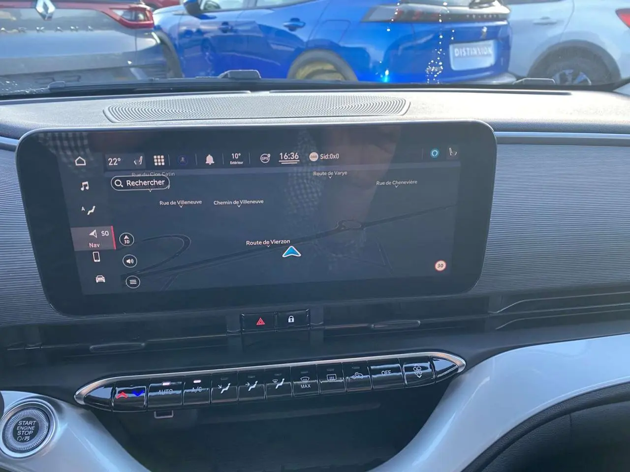 Tableau de bord de la Fiat 500 électrique noire 2022 avec écran tactile de navigation et commandes climatisation visibles.