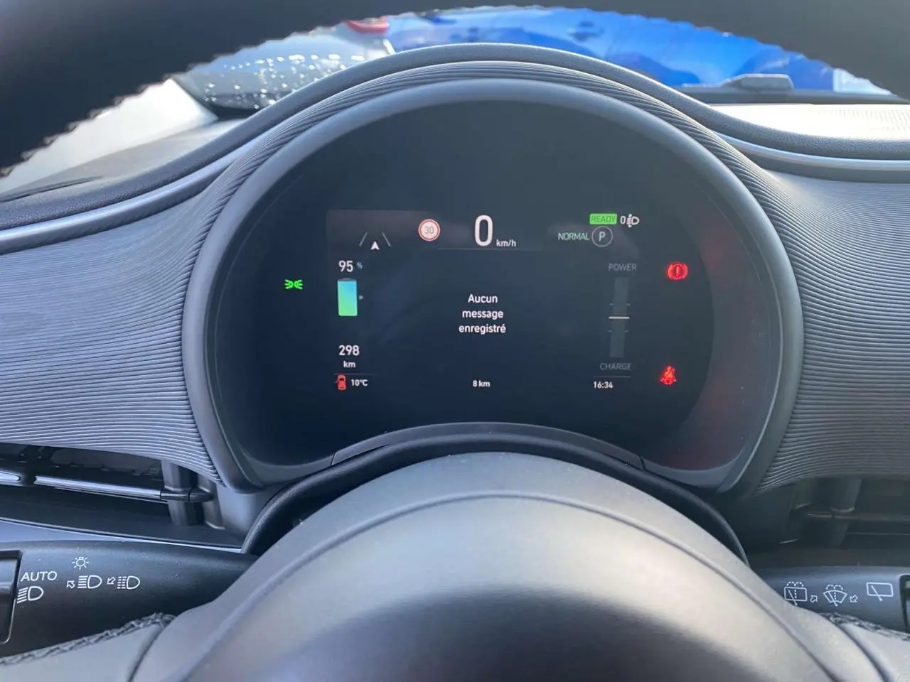 Vue rapprochée du tableau de bord numérique de la FIAT 500 électrique noire, affichant vitesse et autonomie.