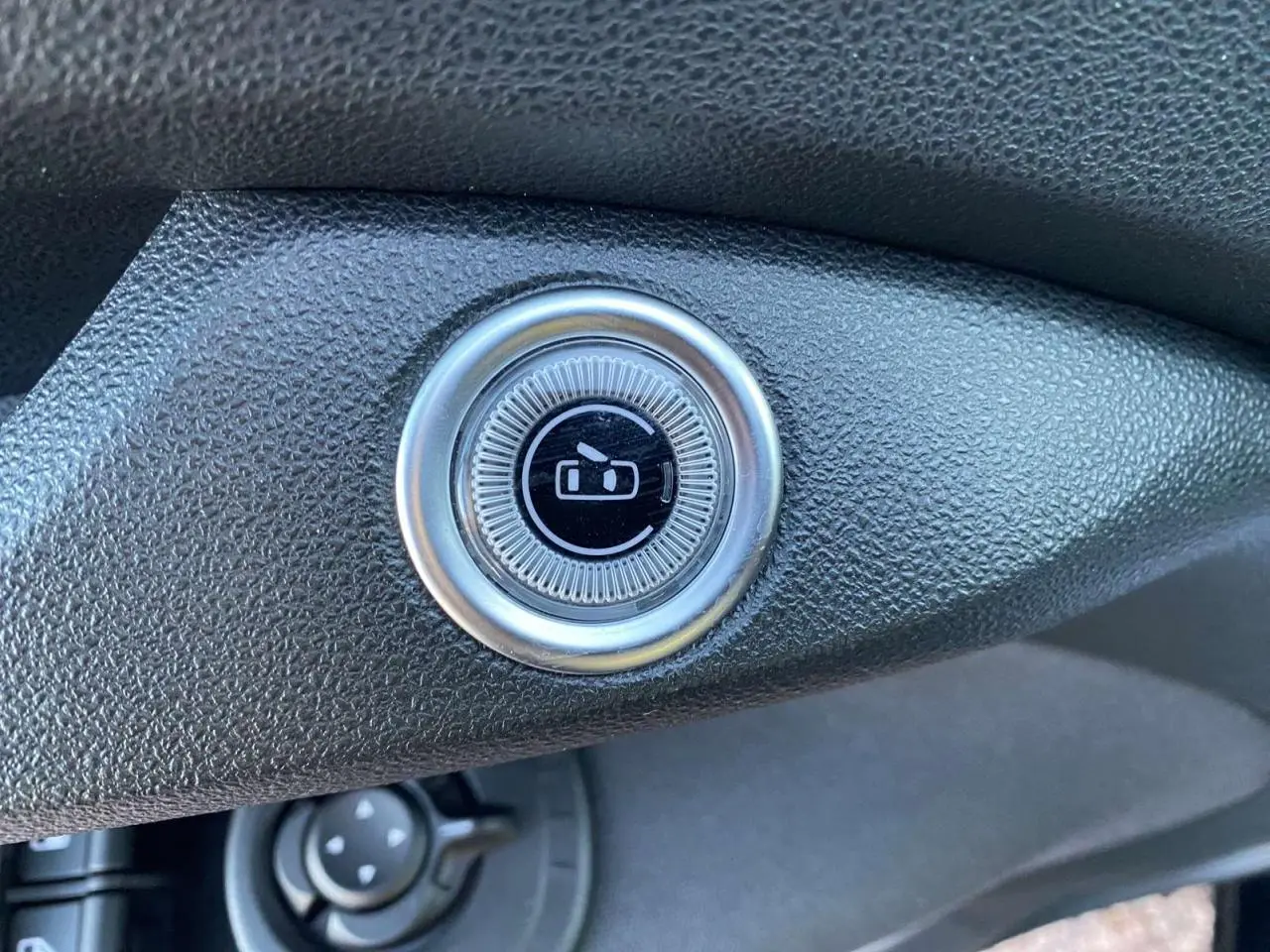 Bouton rond de commande des rétroviseurs sur tableau de bord noir de la Fiat 500 électrique 2022.