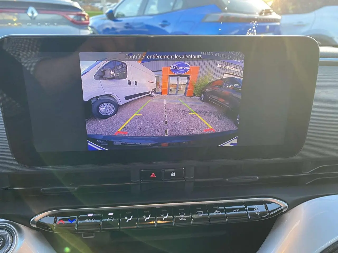 Écran central montrant la caméra de recul d'une Fiat 500 électrique noire, vue intérieure du tableau de bord.