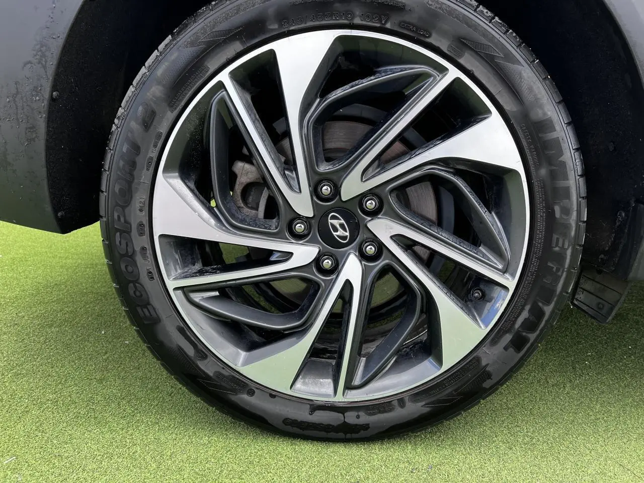 Gros plan sur la jante alliage 17'' bicolore du Hyundai Tucson III rouge métallisé, avec pneu Ecospot.