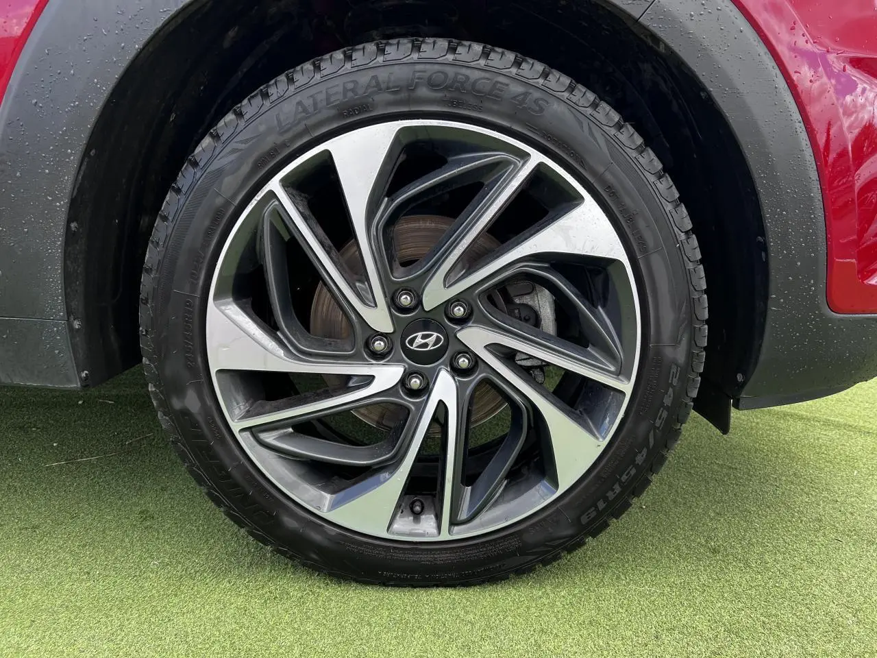 Gros plan sur la jante alliage 17'' bicolore du Hyundai Tucson rouge métallisé, avec flanc de pneu visible.
