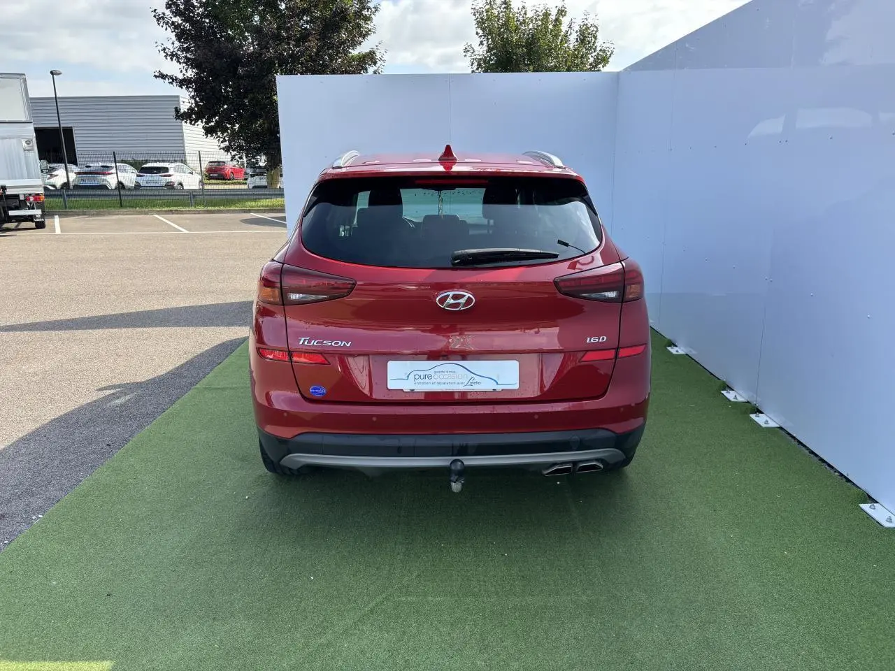 Vue arrière d'un Hyundai Tucson rouge métallisé 2020 avec attelage et double sortie d'échappement visible.
