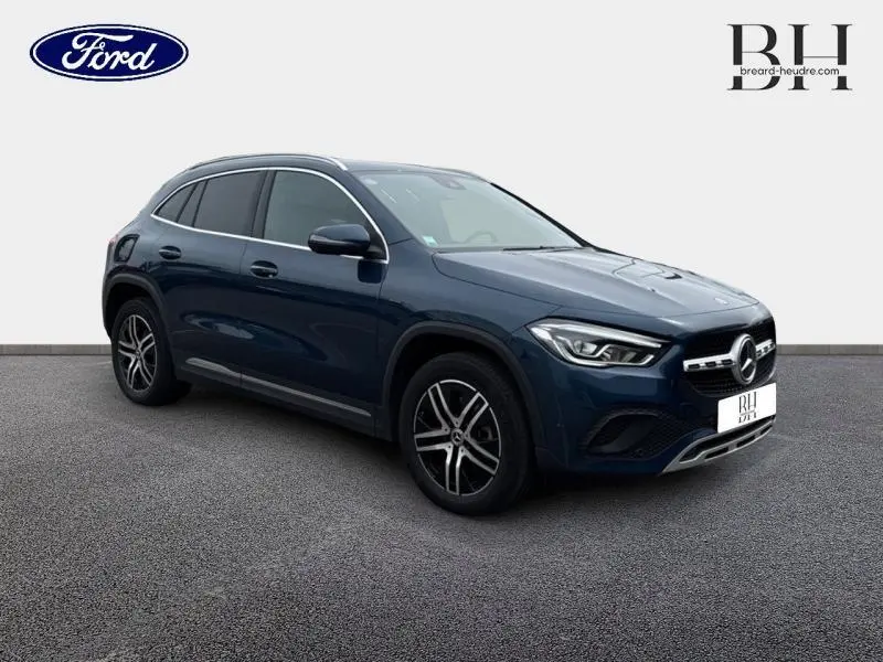 Mercedes GLA 250 e hybride bleu denim métallisé en 3/4 avant droit, avec jantes alliage et calandre distinctive.