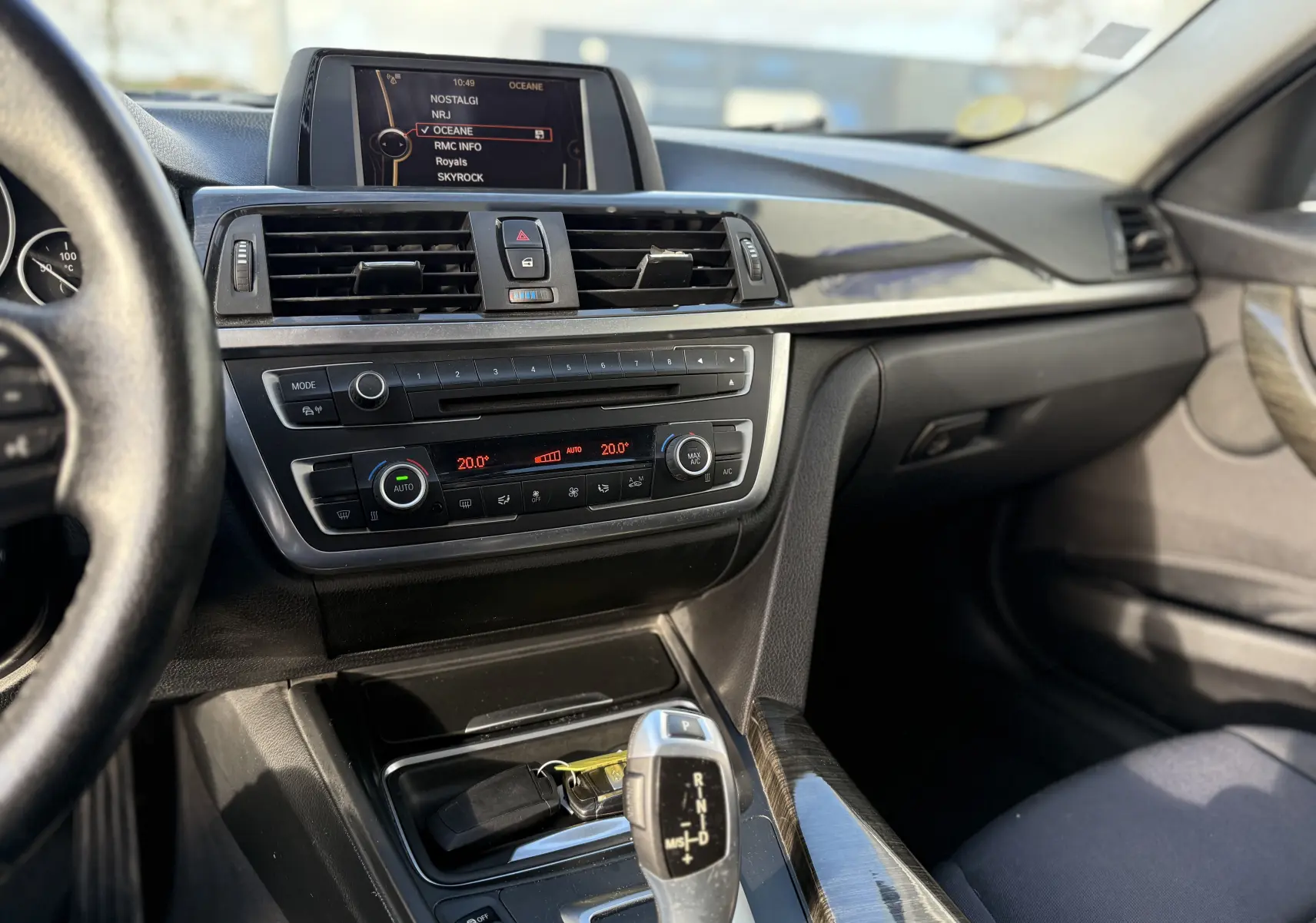 Intérieur de BMW Série 3 320D 2013 montrant le tableau de bord, la console centrale avec boîte auto et écran multimédia.