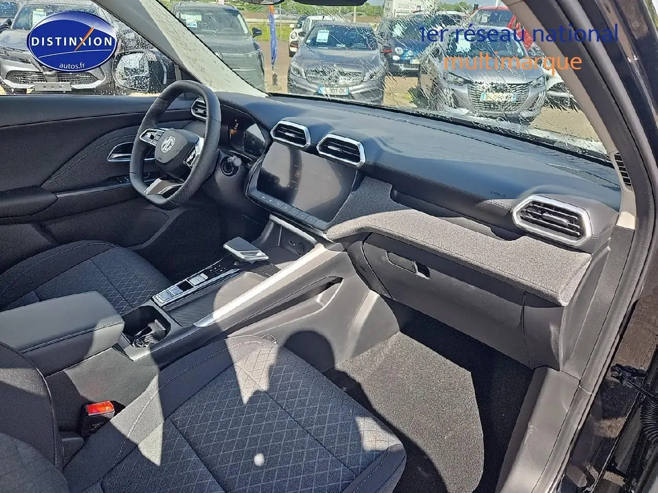 Intérieur avant du MG ZS Hybrid 197 noir, vue côté passager montrant tableau de bord et écran tactile 10,25 pouces.