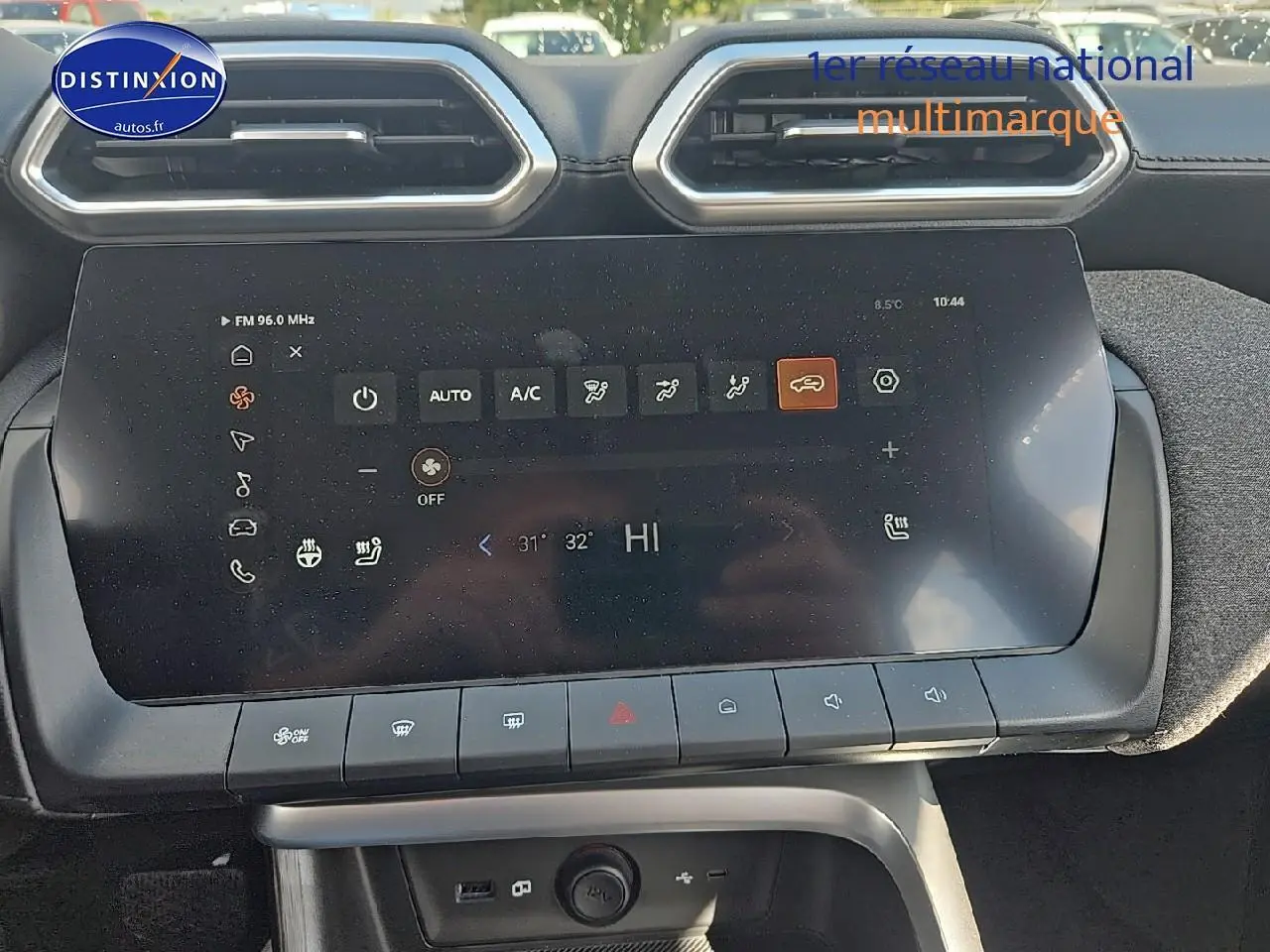 Écran tactile central du tableau de bord du MG ZS Hybrid noir, avec commandes climatisation visibles.