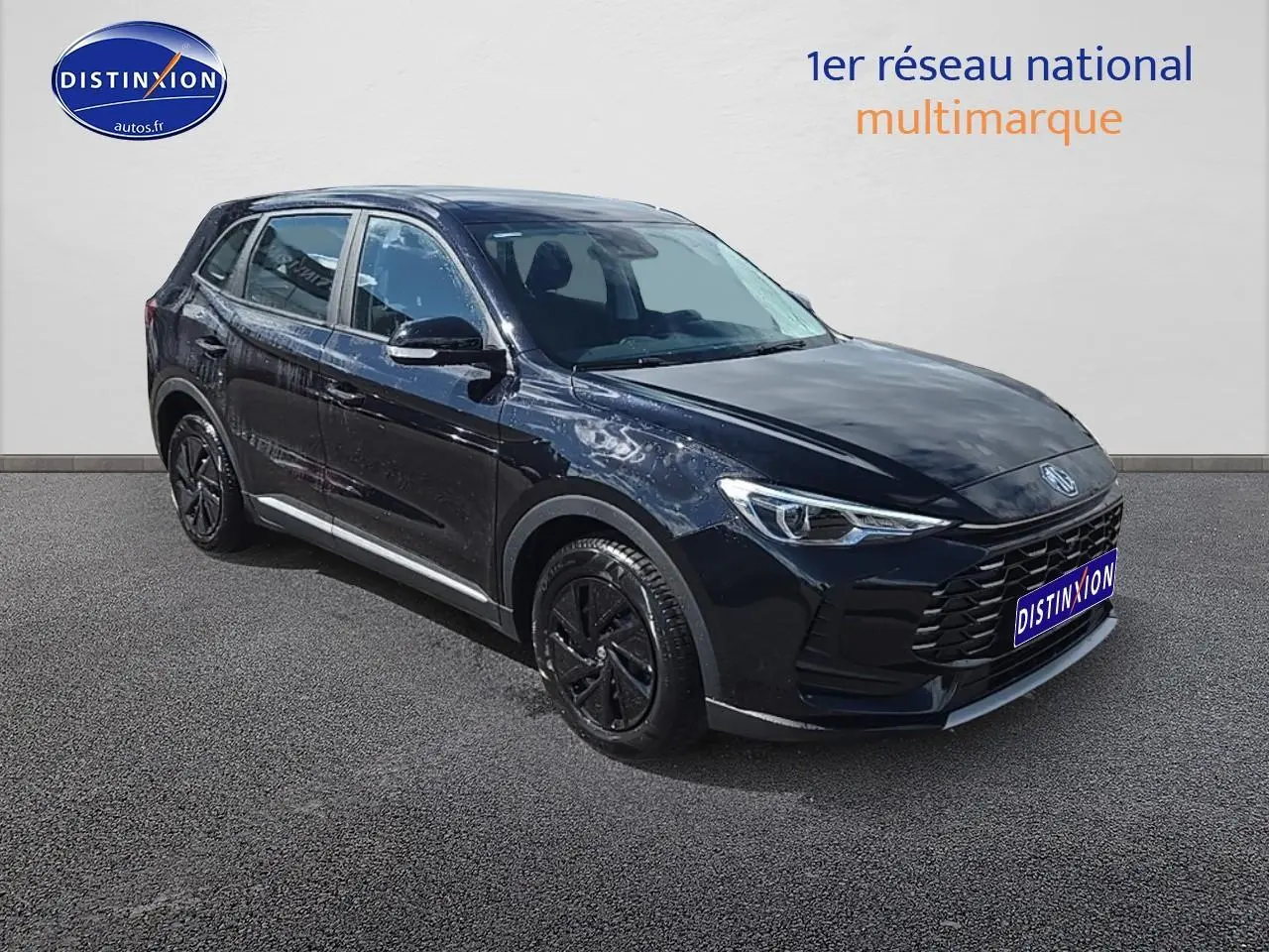 MG ZS Hybrid noir en 3/4 avant droit, avec jantes noires et calandre imposante sur fond neutre.
