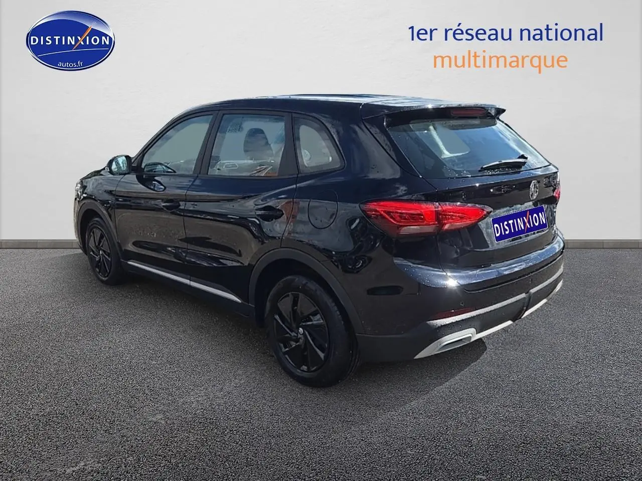 Vue 3/4 arrière droite du SUV noir MG ZS Hybrid 197 avec jantes noires et feux arrière LED allumés.