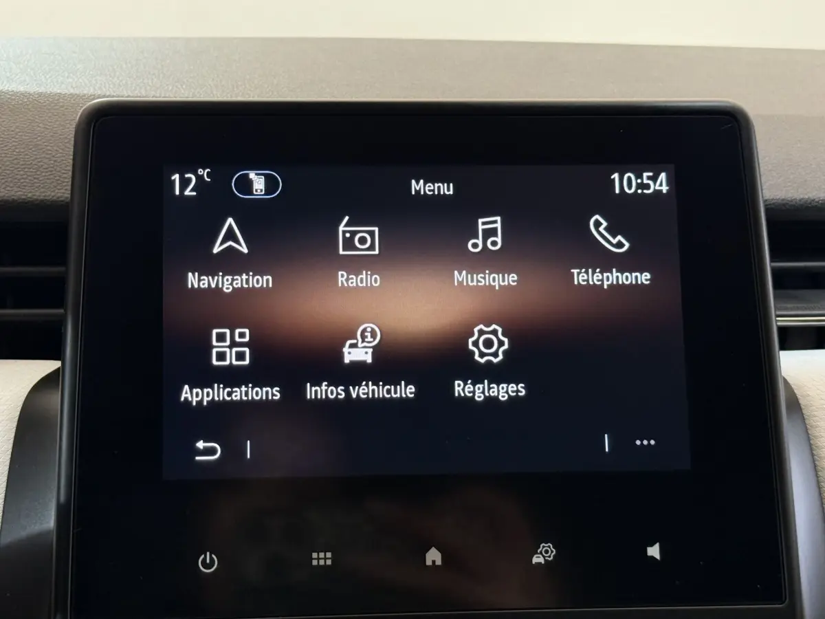 Écran tactile central de la Renault Clio blanche 2023 affichant le menu principal avec navigation et musique.
