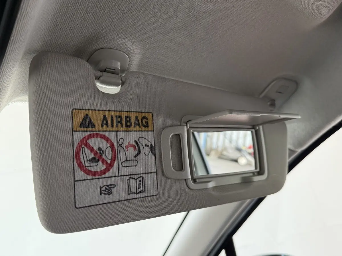 Détail du pare-soleil côté conducteur avec miroir et avertissement airbag dans une Renault Clio blanche.