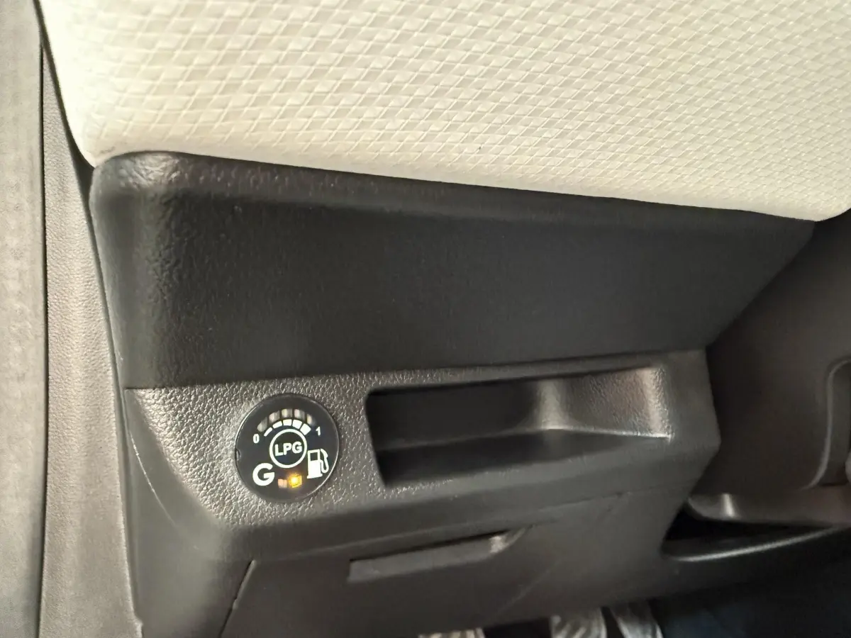 Gros plan sur le tableau de bord noir et beige de la Renault Clio blanc, avec indicateur de niveau GPL allumé.