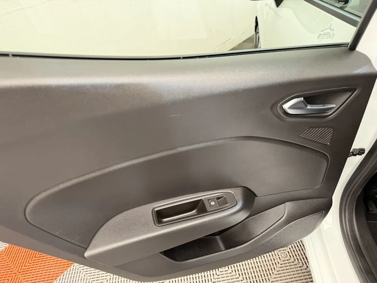 Vue intérieure de la porte arrière droite noire d’une Renault Clio blanche Evolution TCe 100 GPL 2023.