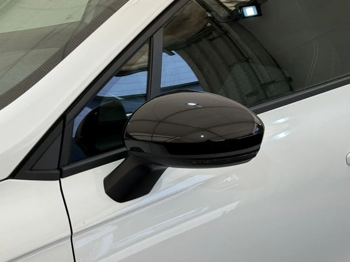 Rétroviseur noir brillant côté gauche sur porte blanche d’une Renault Clio Evolution TCe 100 GPL 2023.