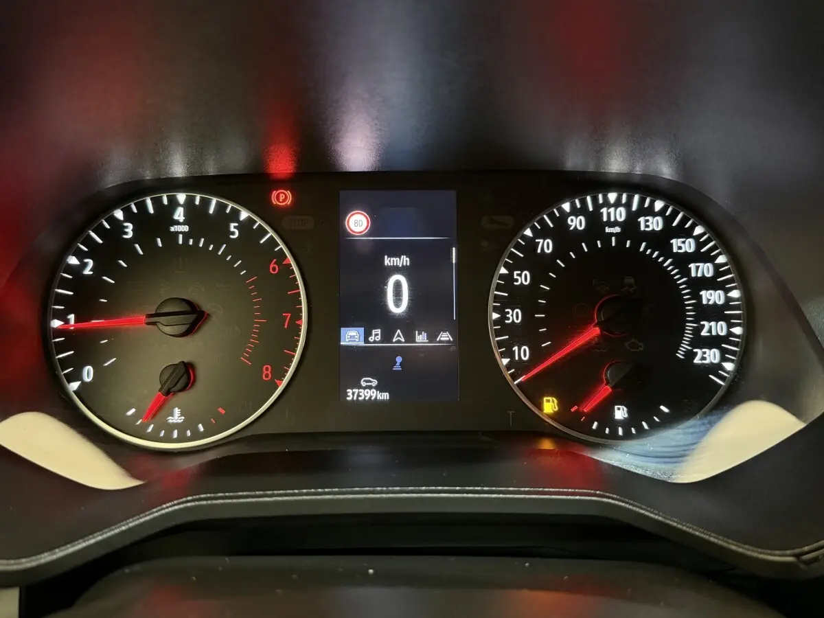 Tableau de bord de Renault Clio blanc Evolution TCe 100 GPL 2023, affichage digital au centre et compteurs analogiques.