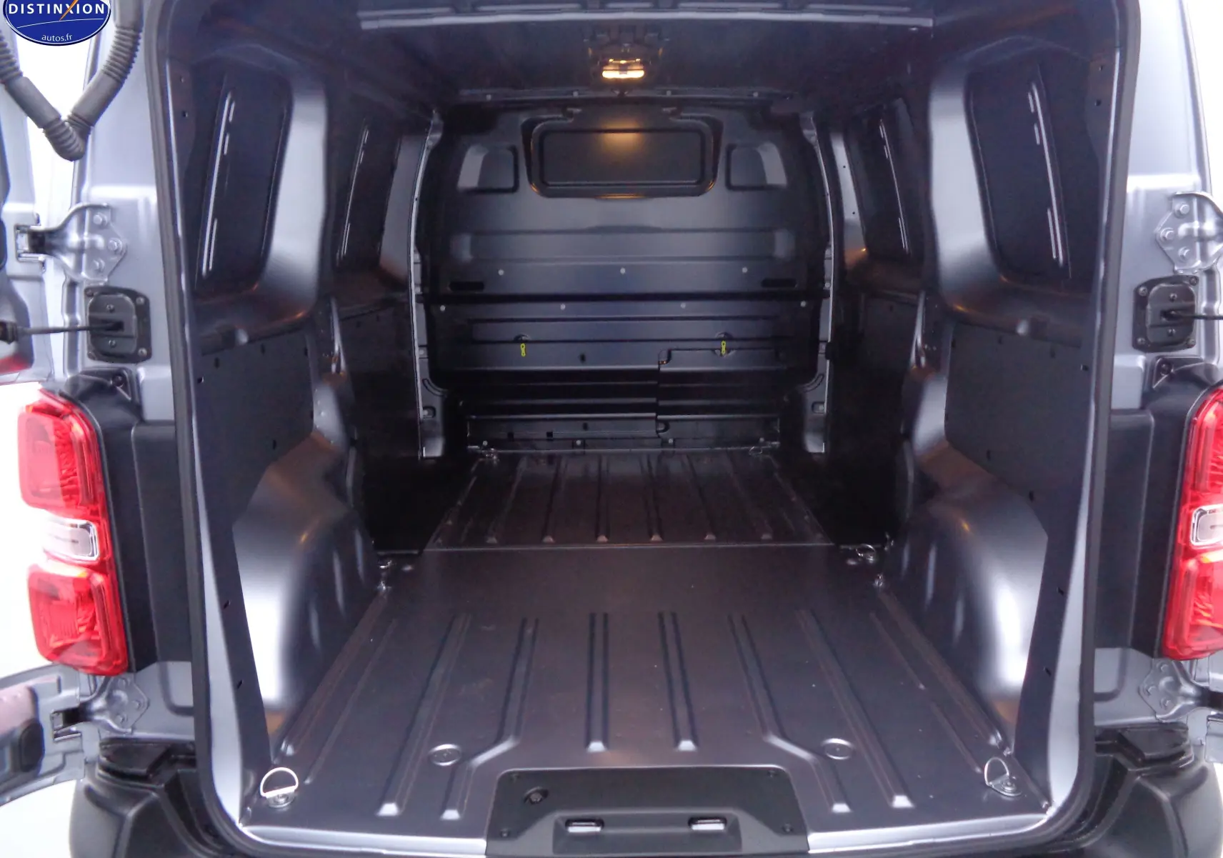 Vue arrière ouverte du Peugeot Expert Fourgon gris Artense Métal, montrant l'espace de chargement vide et métallique.